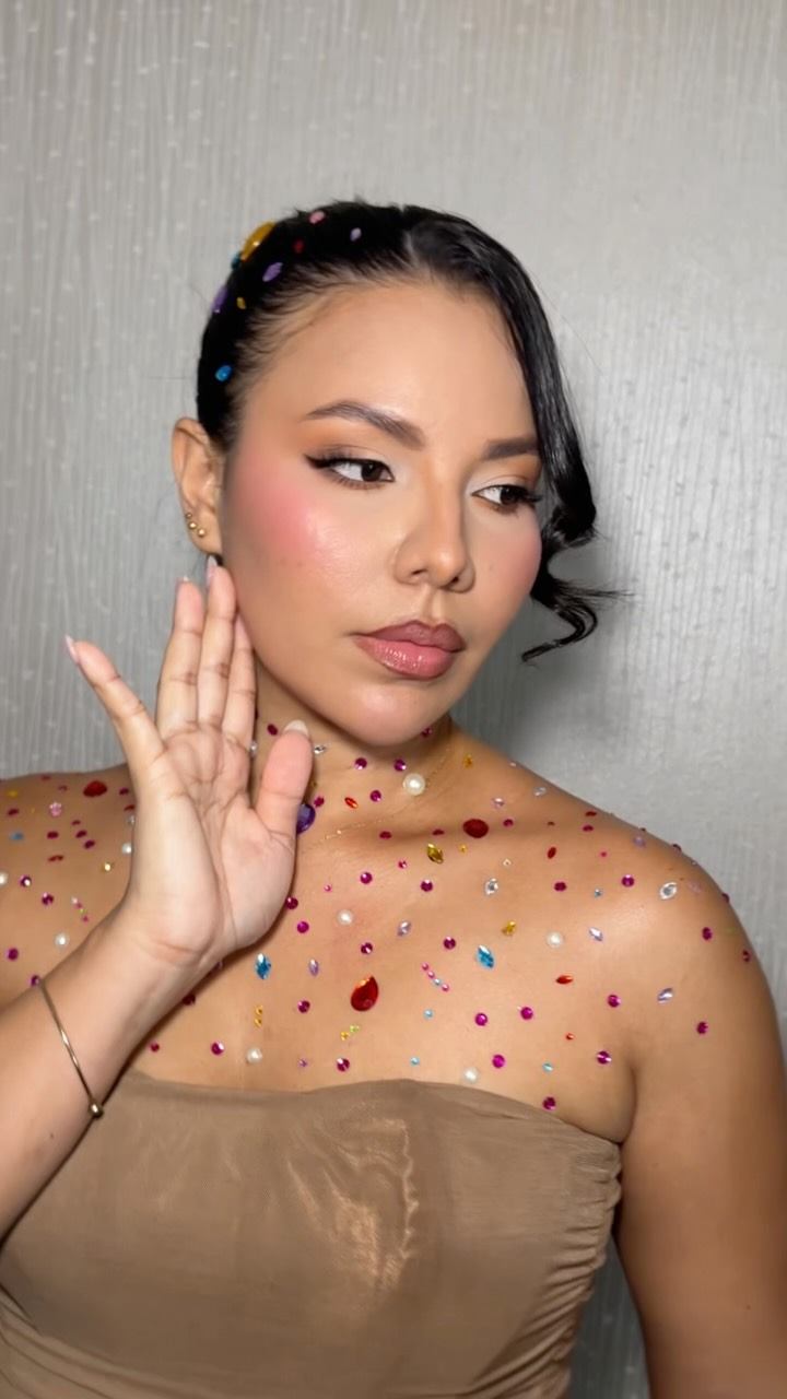 Detalle del maquillaje con pedrería y peinado con trenzas
